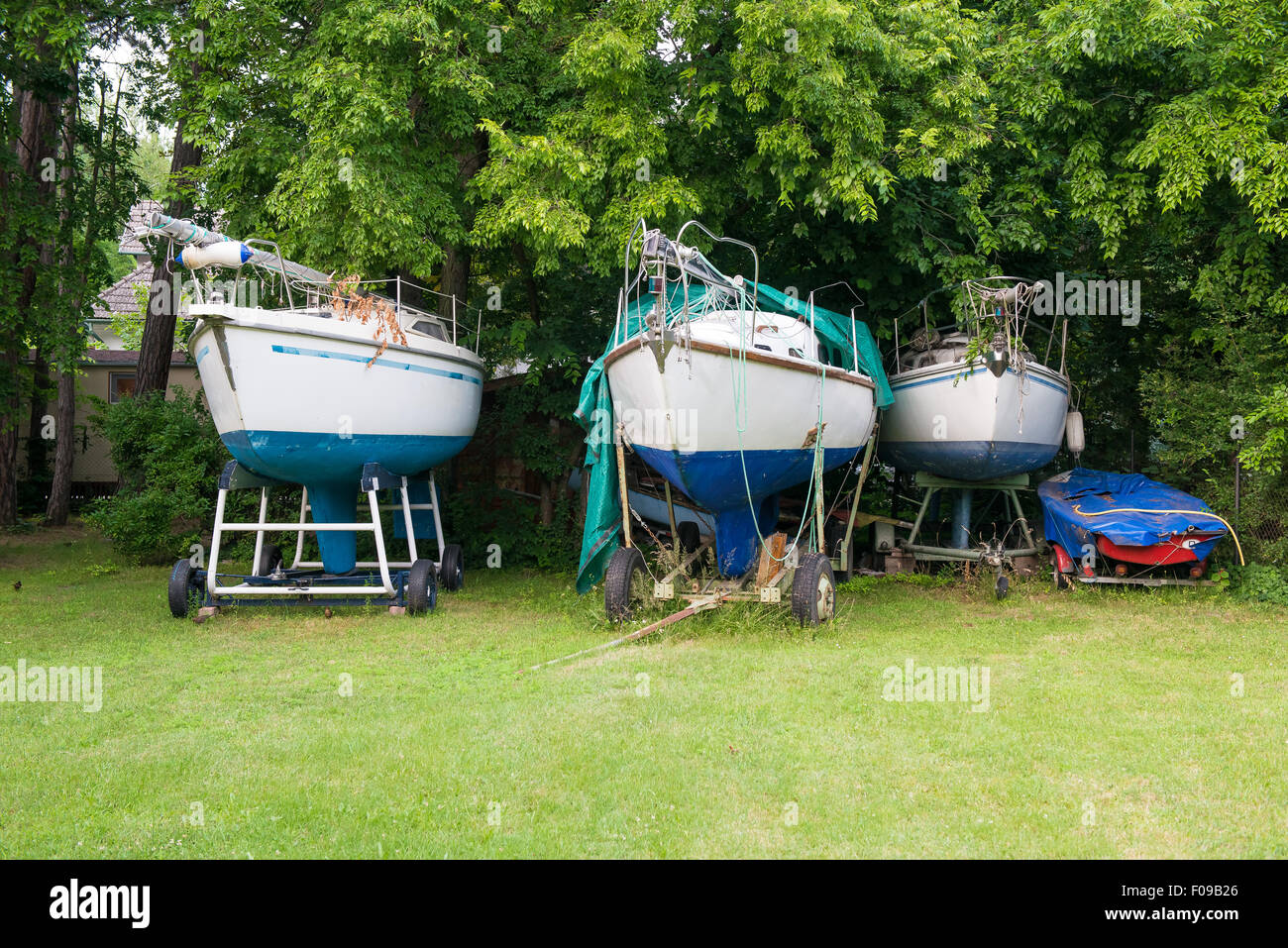 Boote auf Trailern im Garten gespeichert Stockfoto