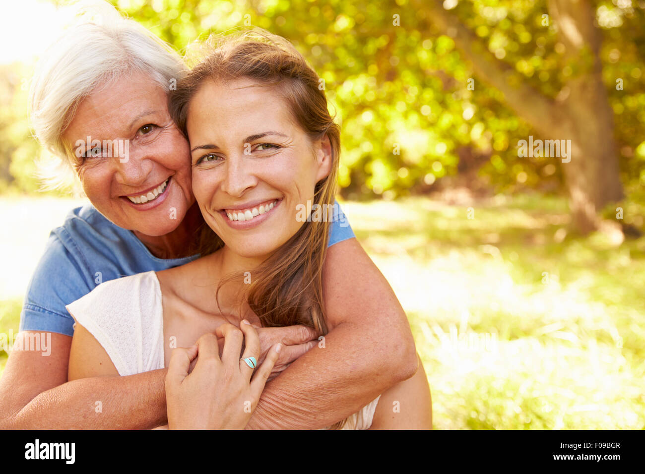Ältere Frau sitzt im Freien mit ihrer erwachsenen Tochter Stockfoto