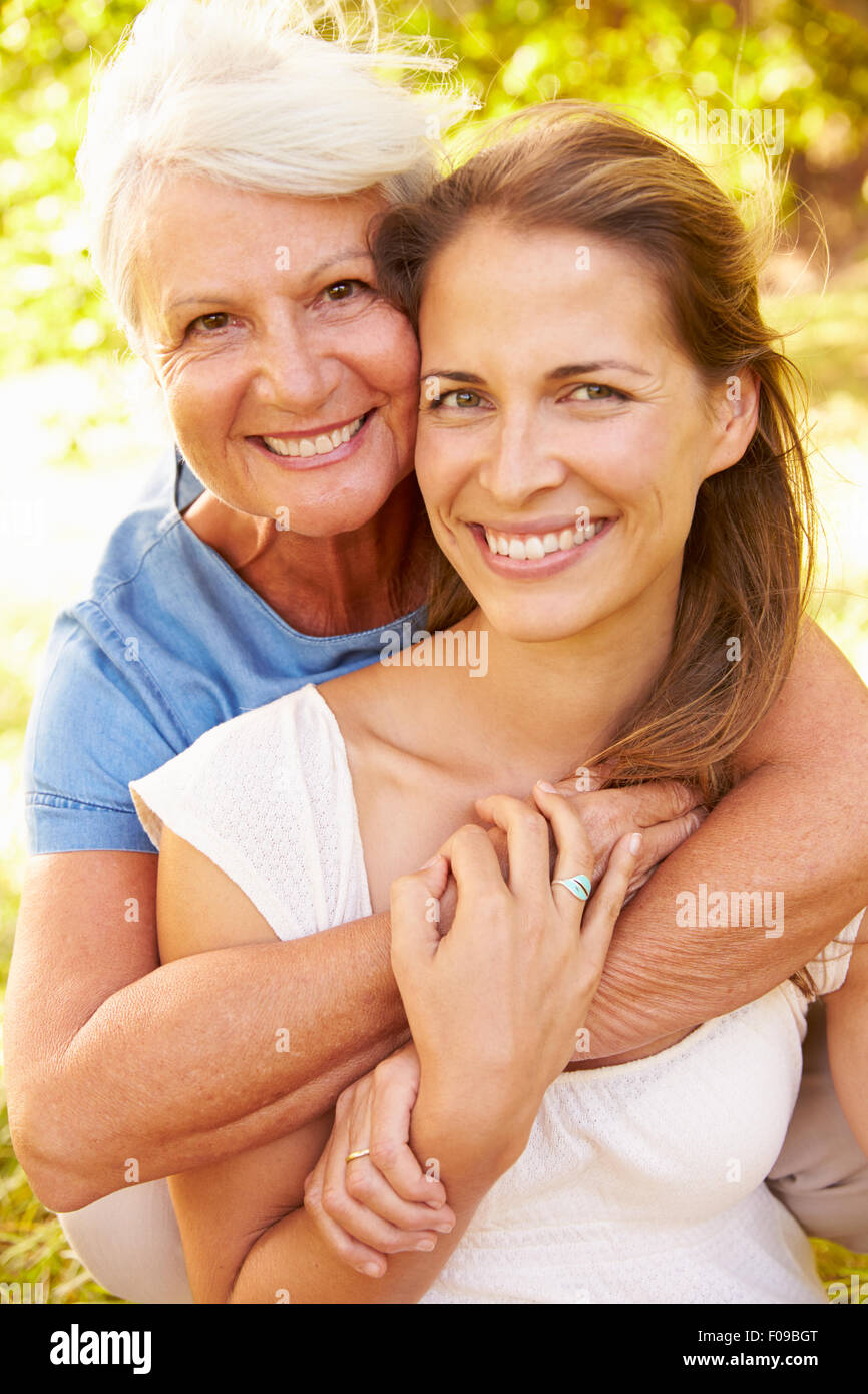 Ältere Frau sitzt im Freien mit ihrer erwachsenen Tochter Stockfoto