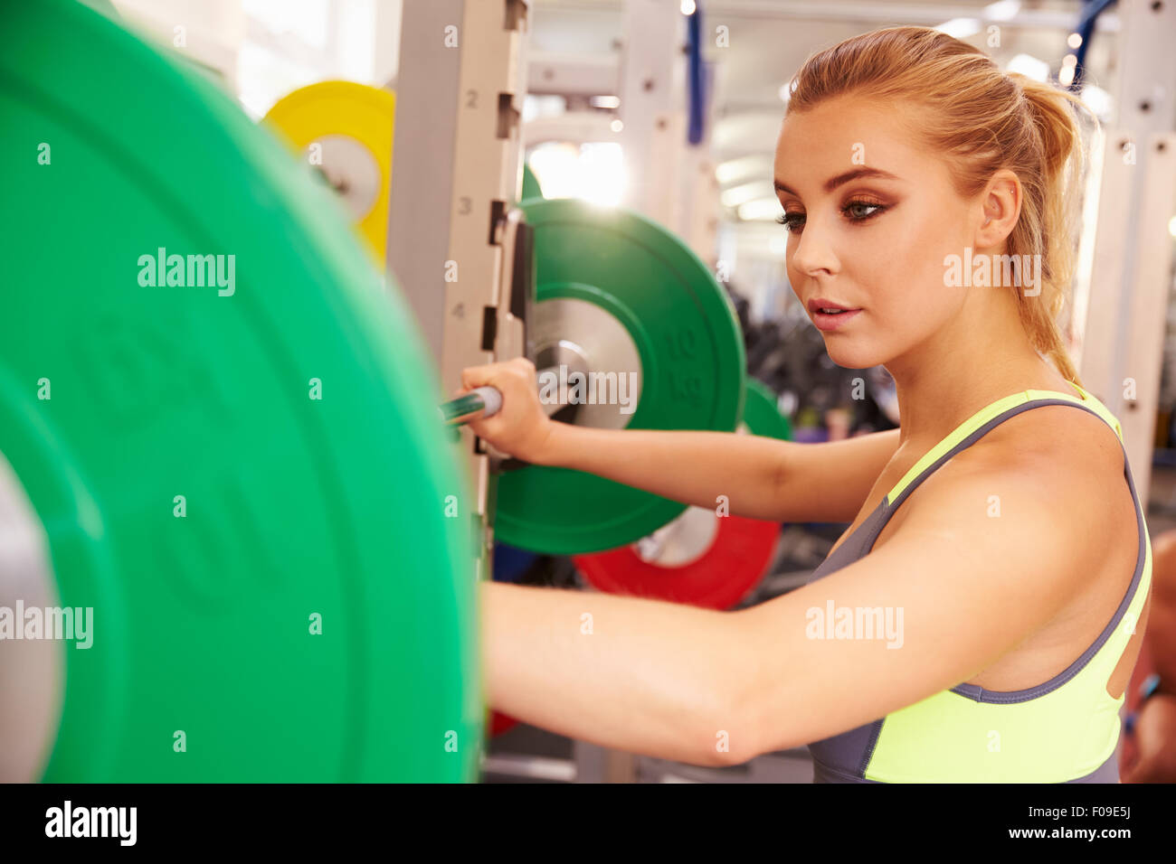 Frau an einem squat Rack in einem Fitnessstudio Hanteln heben wird vorbereitet Stockfoto