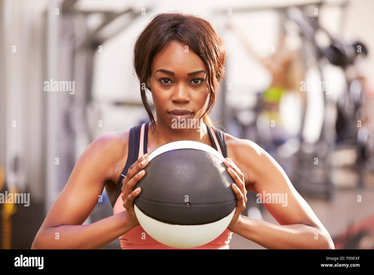 Porträt einer Frau mit einem Medizinball in einem Fitnessstudio Stockfoto