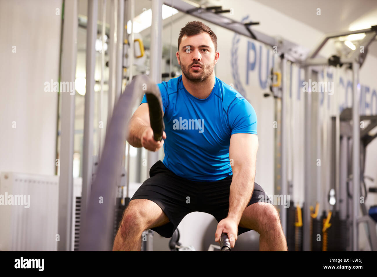 Junger Mann mit Schlacht Seilen in einem Fitnessstudio trainieren Stockfoto