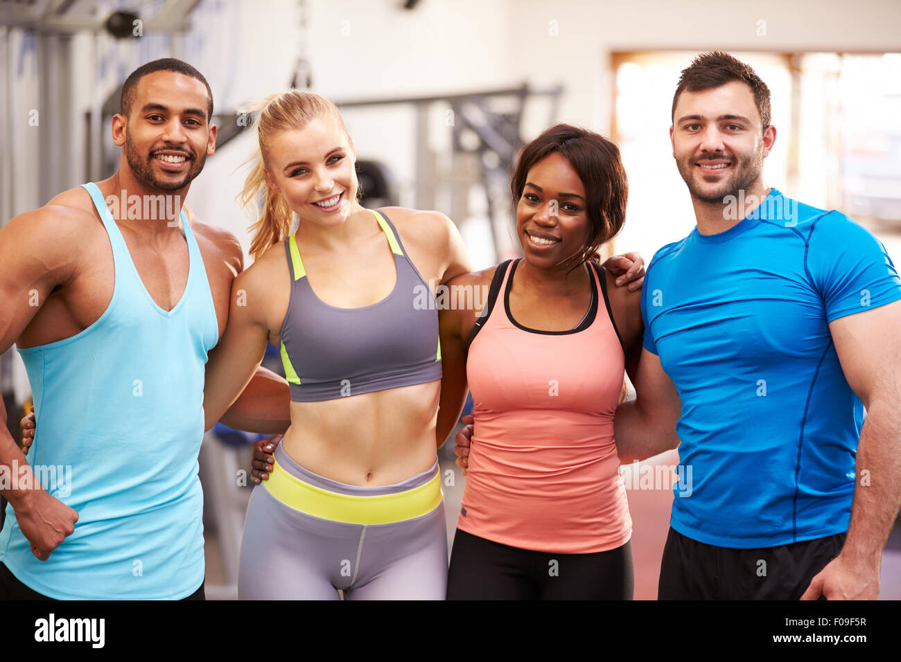 Glückliche Gruppe Gym buddies mit Arme umeinander Stockfoto