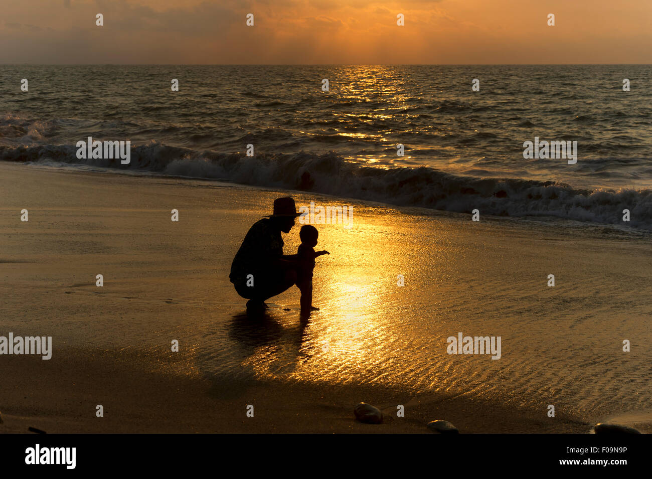 Vater-Baby-Silhouette ist ein liebevoll sein Kind zeigt das Meer zum ersten Mal Vater. Stockfoto