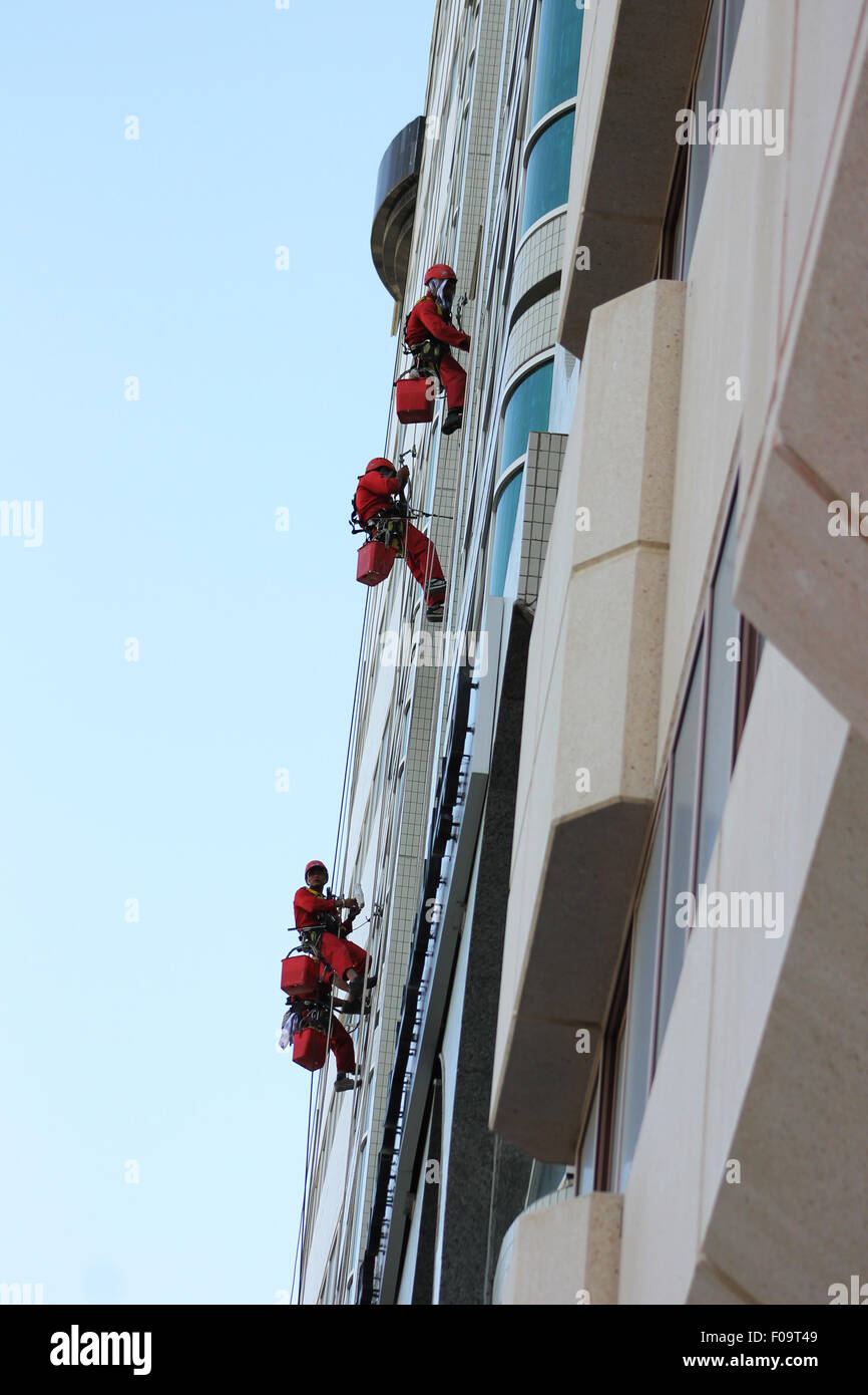 Riskante Aufgabe - Fensterputzer bei der Arbeit auf ein Hochhaus mit Bootsmann Stuhl und RDS-system Stockfoto