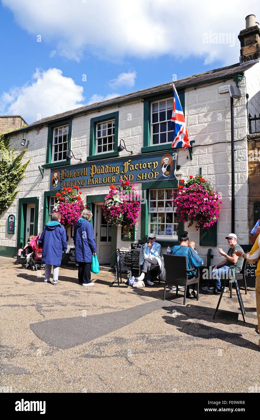 Touristen sitzen in einem Straßencafé außerhalb der Bakewell Pudding Fabrik im Zentrum Stadt, Bakewell, Derbyshire, England, Vereinigtes Königreich, Stockfoto