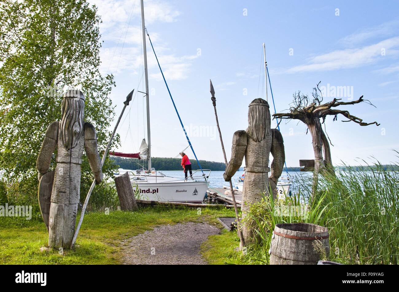 Zwei Holzskulpturen vor See in Galindia Mazurski Eden, Ermland-Masuren, Polen Stockfoto