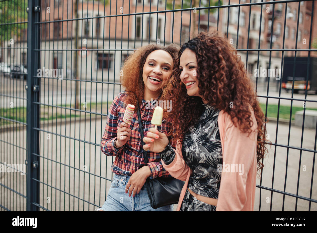 Glückliche Frauen ein Eis im Freien zu essen. Freundinnen Spaß am Stadtstraße. Stockfoto