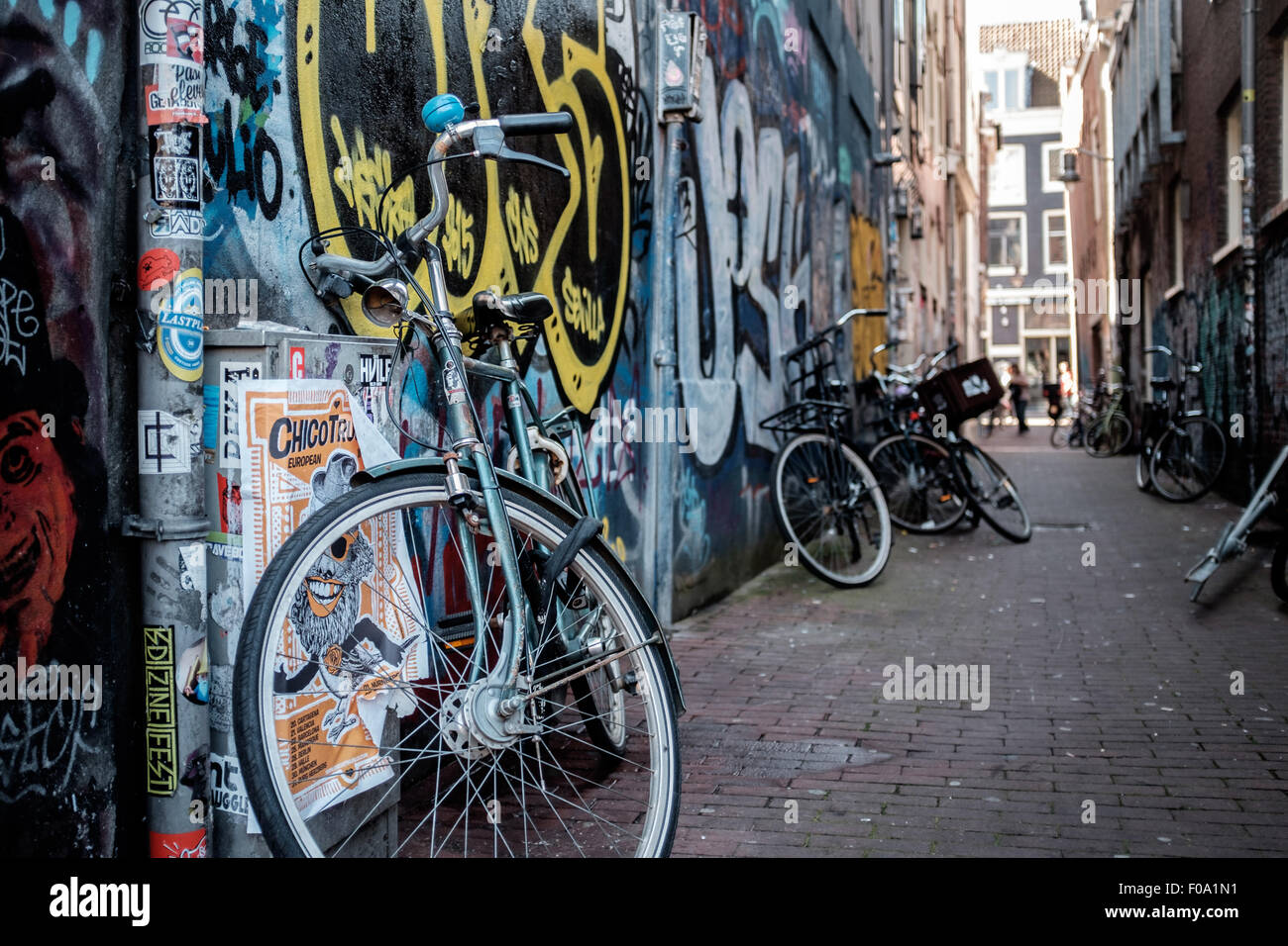 Fahrrad in einer Gasse in Amsterdam, an einem städtischen Wand von grafitti Stockfoto