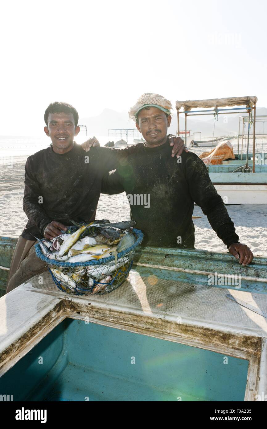 Zwei Fischer Mann mit Fischen vorne auf Maghsil Bay Strand in Salalah, Dhofar, Oman Stockfoto