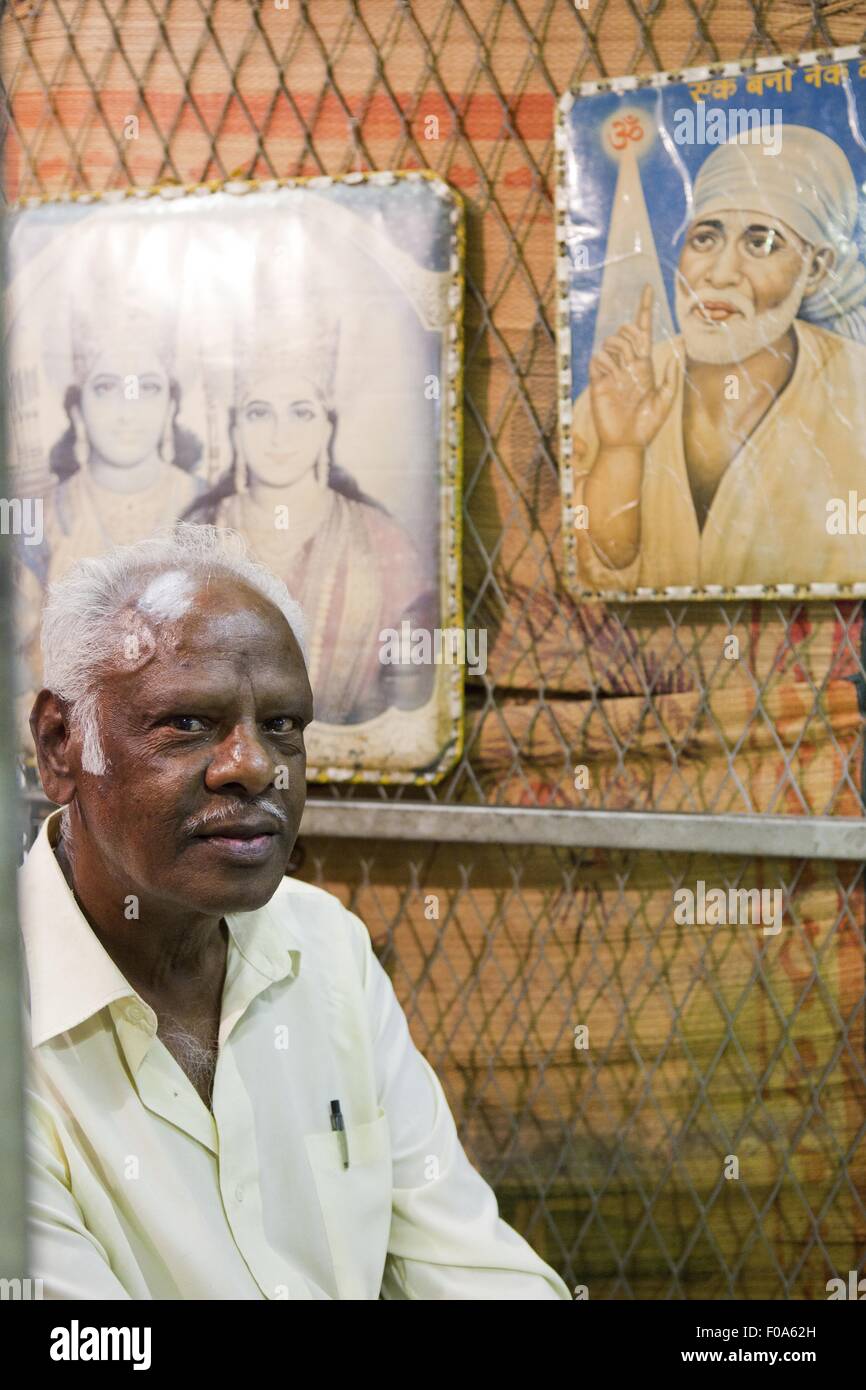 Porträt der ältere Mann mit Heiligenbildern an auf Metallrahmen im Hintergrund Stockfoto