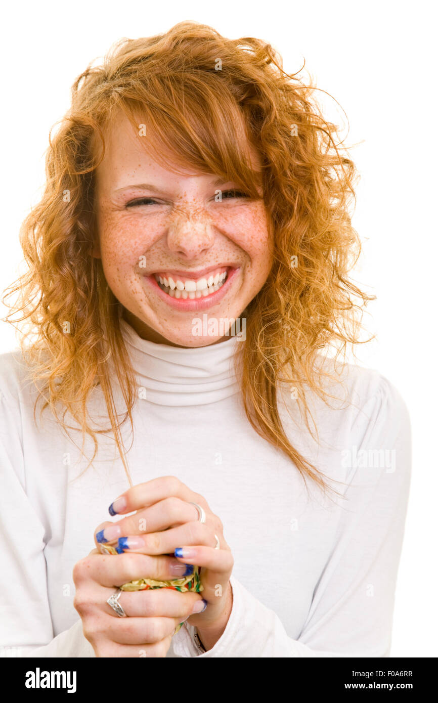 Glückliche junge rothaarige Frau wegwerfen Geschenkpapier Stockfoto