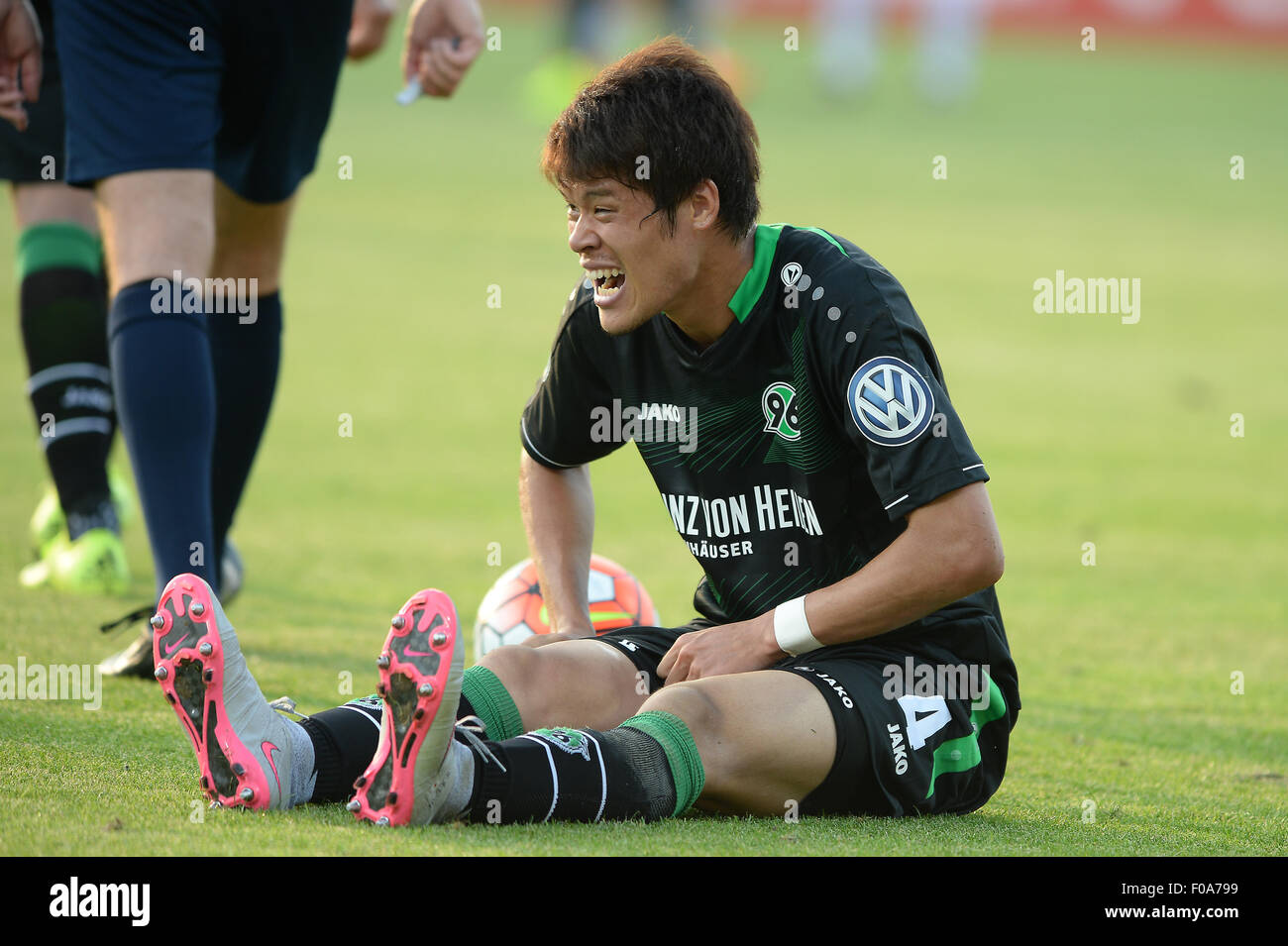 Kassel, Deutschland. 9. August 2015. Hannovers Hiroki Sakai sitzt auf dem Spielfeld nach wird in den deutschen Fußball DFB-Pokal ersten Vorrundenspiel zwischen KSV Hessen Kassel und Hannover 96 am Auestadion in Kassel, Deutschland, 9. August 2015 gefoult. Foto: Swen Pfoertner/Dpa/Alamy Live News Stockfoto