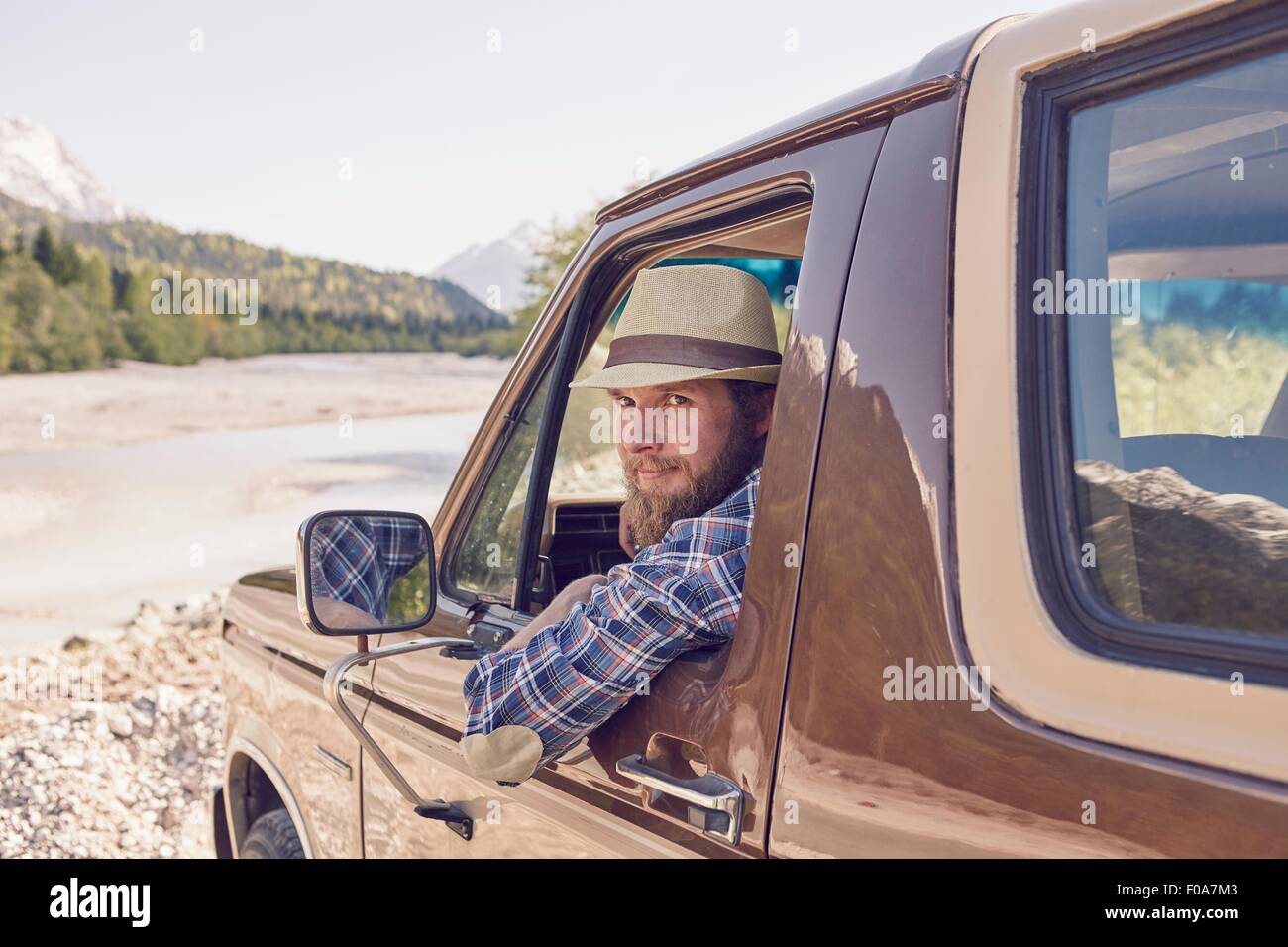 Mitte erwachsenen Mann sitzt in LKW, gelehnt, Fenster, Blick in die Kamera Stockfoto