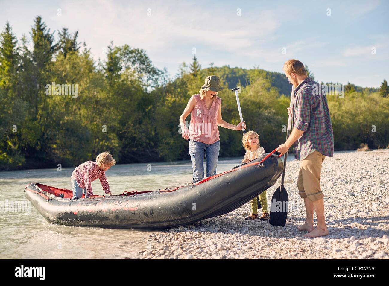 Familienholding ziehen Beiboot auf Ufer, Paddel- Stockfoto