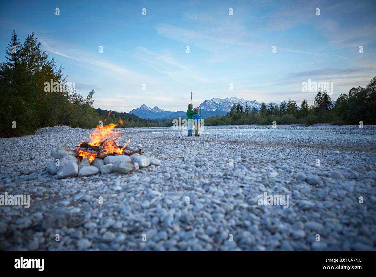 Rückansicht des jungen in der Nähe von Lagerfeuer halten Stöcke, Wallgau, Bayern, Deutschland Stockfoto