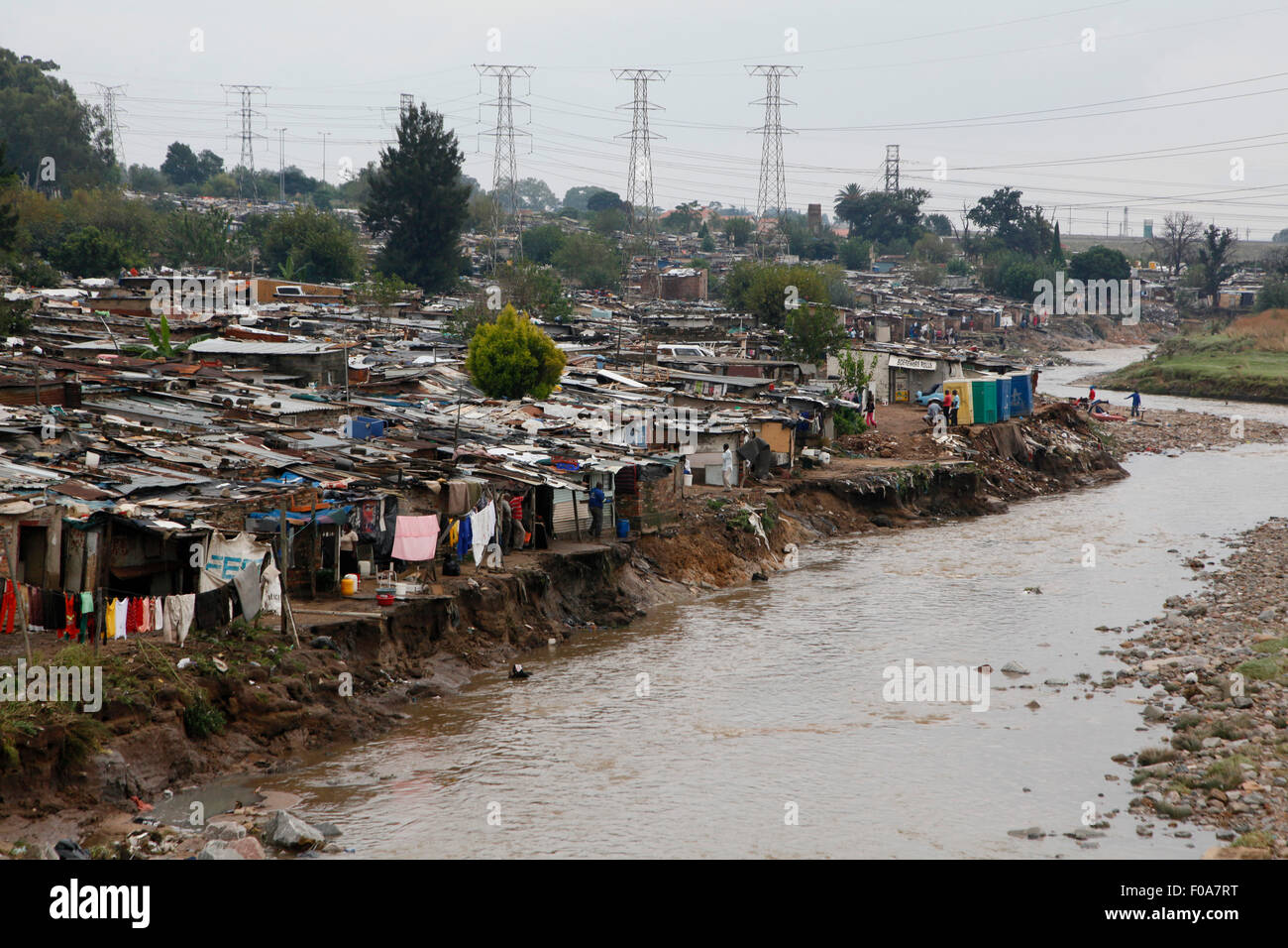 Hütten am Ufer des Flusses Jukskei am Morgen nach Starkregen Häuser überflutet. Alexandra Township. In Johannesburg. Süd-Afr Stockfoto