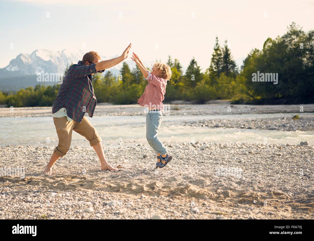 Seitenansicht des jungen Mannes und jungen springen, dabei hohe fünf, Wallgau, Bayern, Deutschland Stockfoto