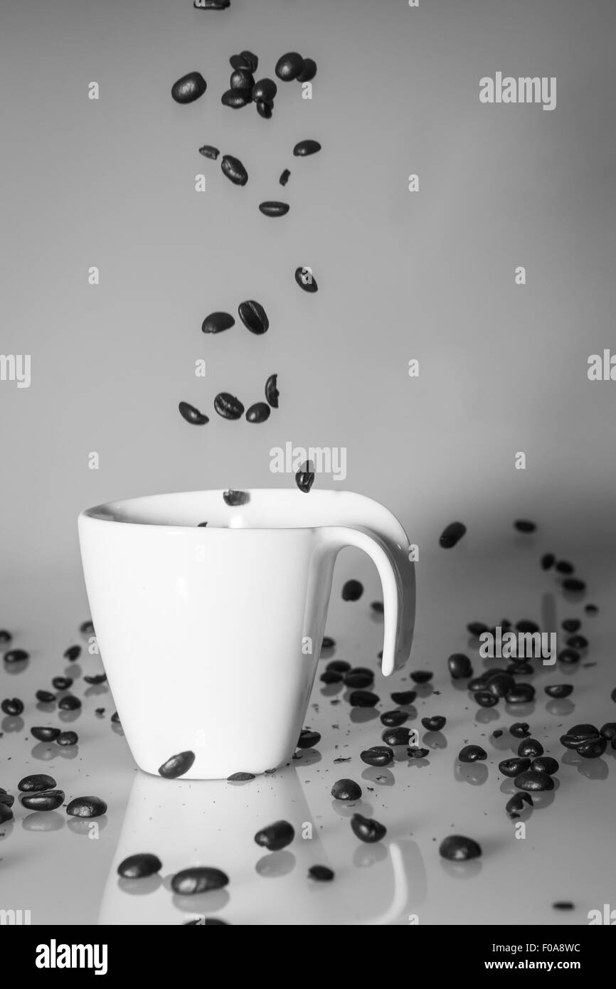 Kaffeebohnen in die Kaffeetasse fallen Stockfoto