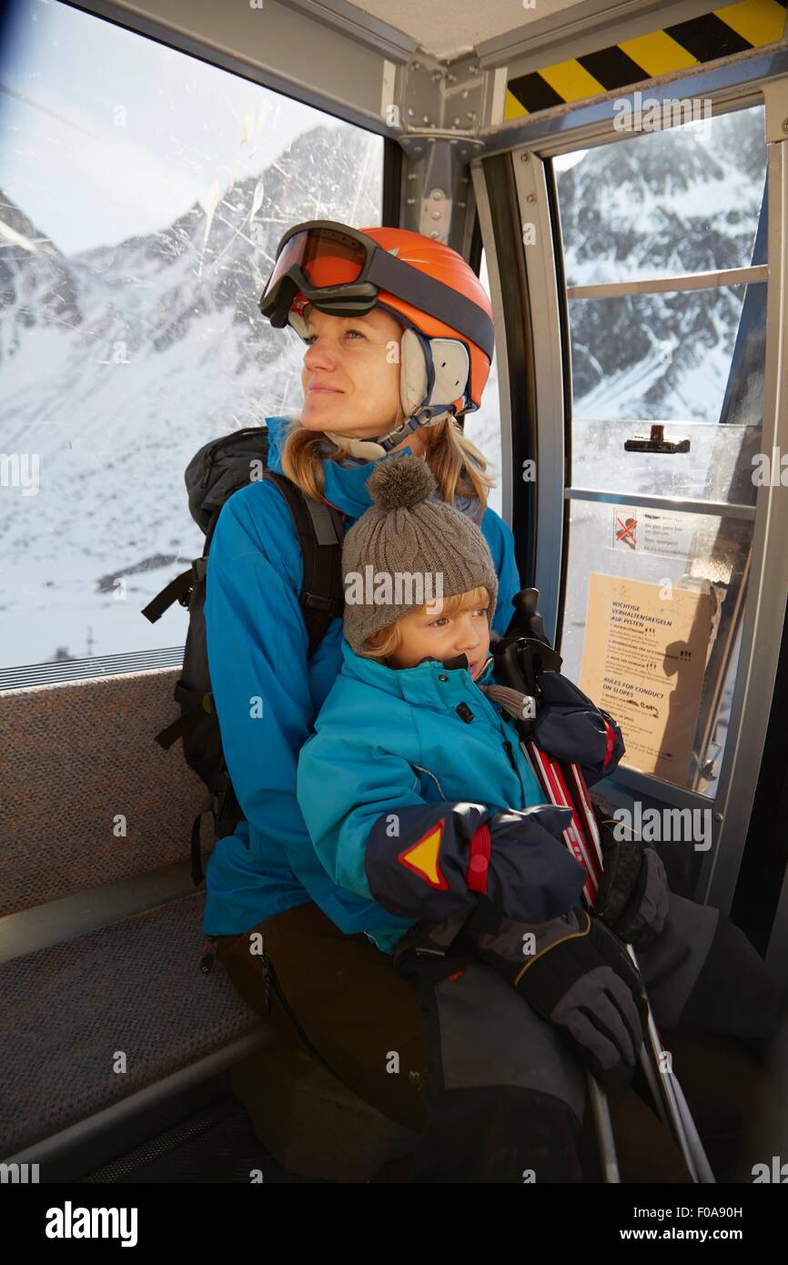 Reife weibliche Skifahrer und Kleinkind Sohn sitzen im Skilift, Neustift, Stubaital, Tirol, Österreich Stockfoto
