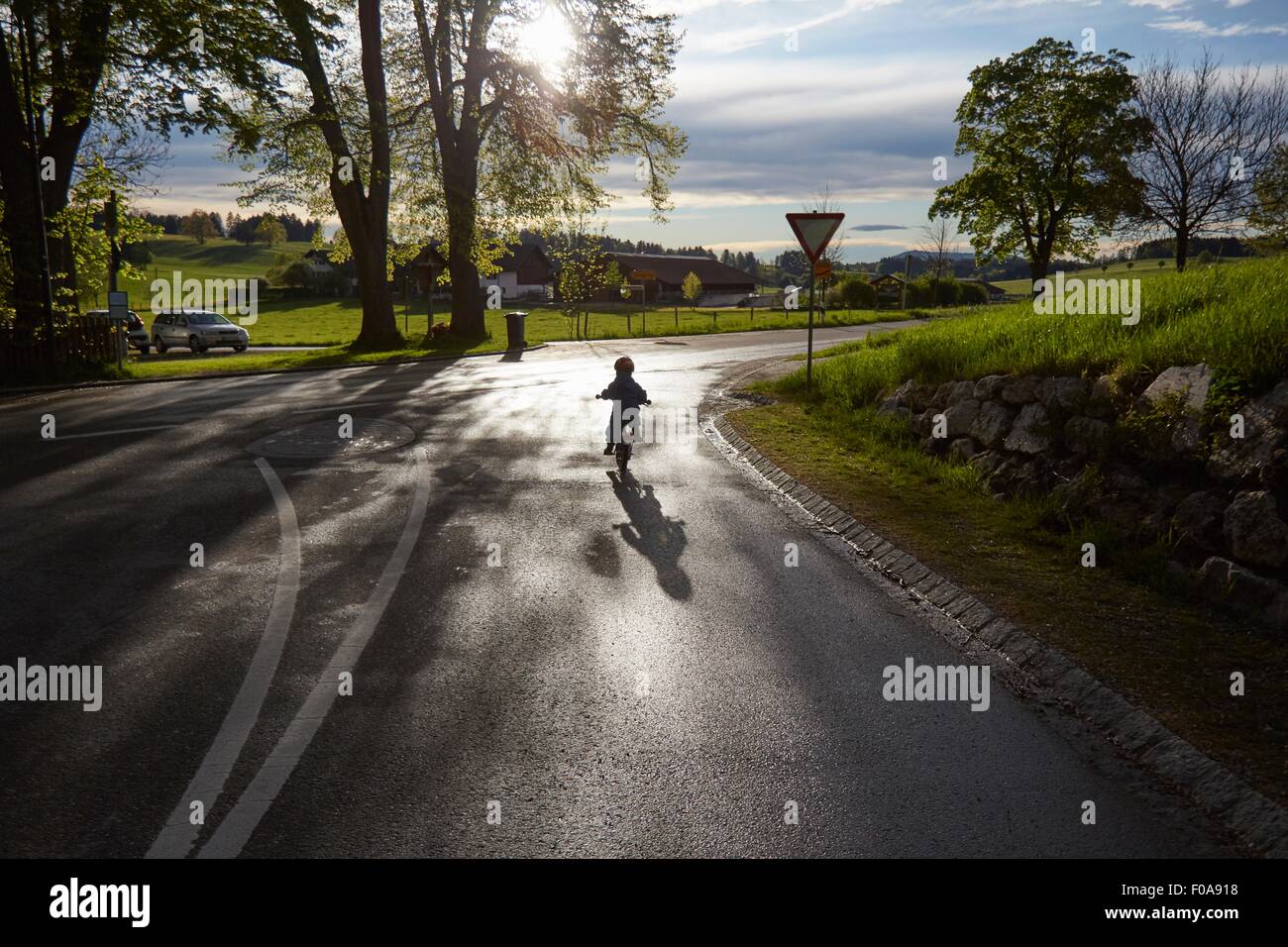 Silhouette Rückansicht eines jungen Radfahren auf Landstraße Stockfoto