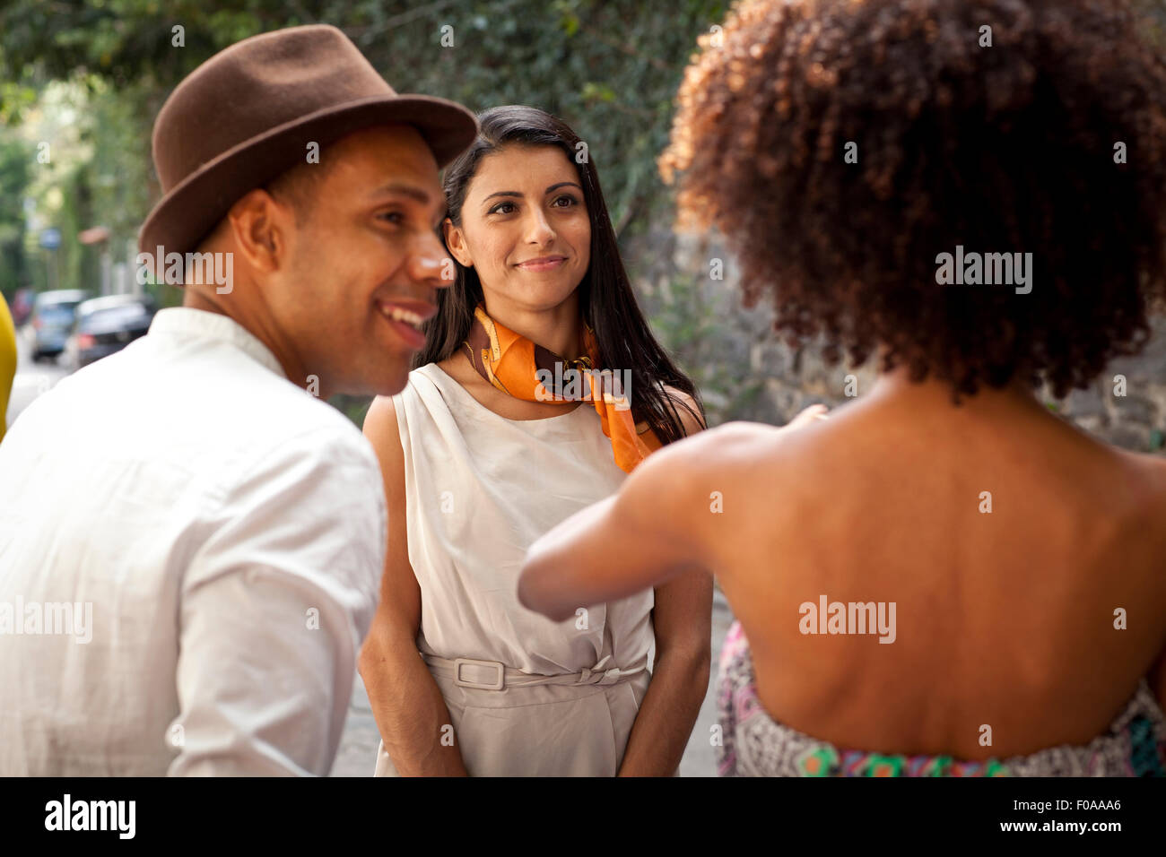 Drei Freunde stehen zusammen, Rückansicht reden, Stockfoto