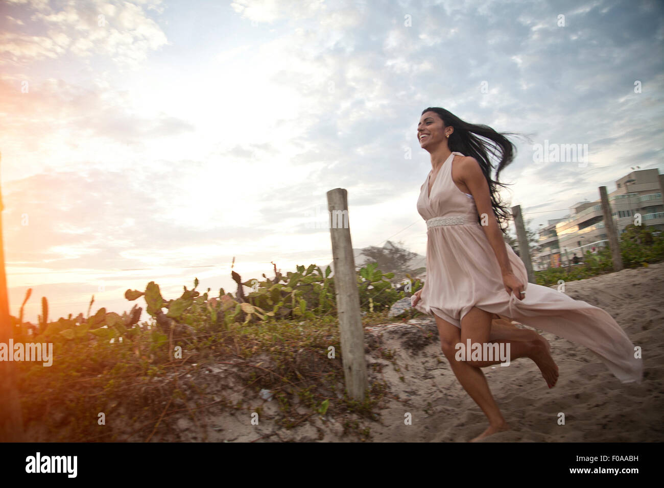 Mitte Erwachsene Frau entlang sandigen Gehweg in Richtung Strand Stockfoto