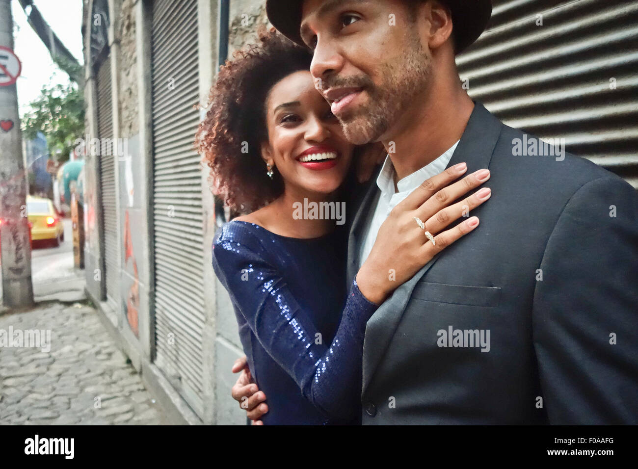 Paar stehen gemeinsam im städtischen Umfeld, Umarmungen, Lächeln Stockfoto