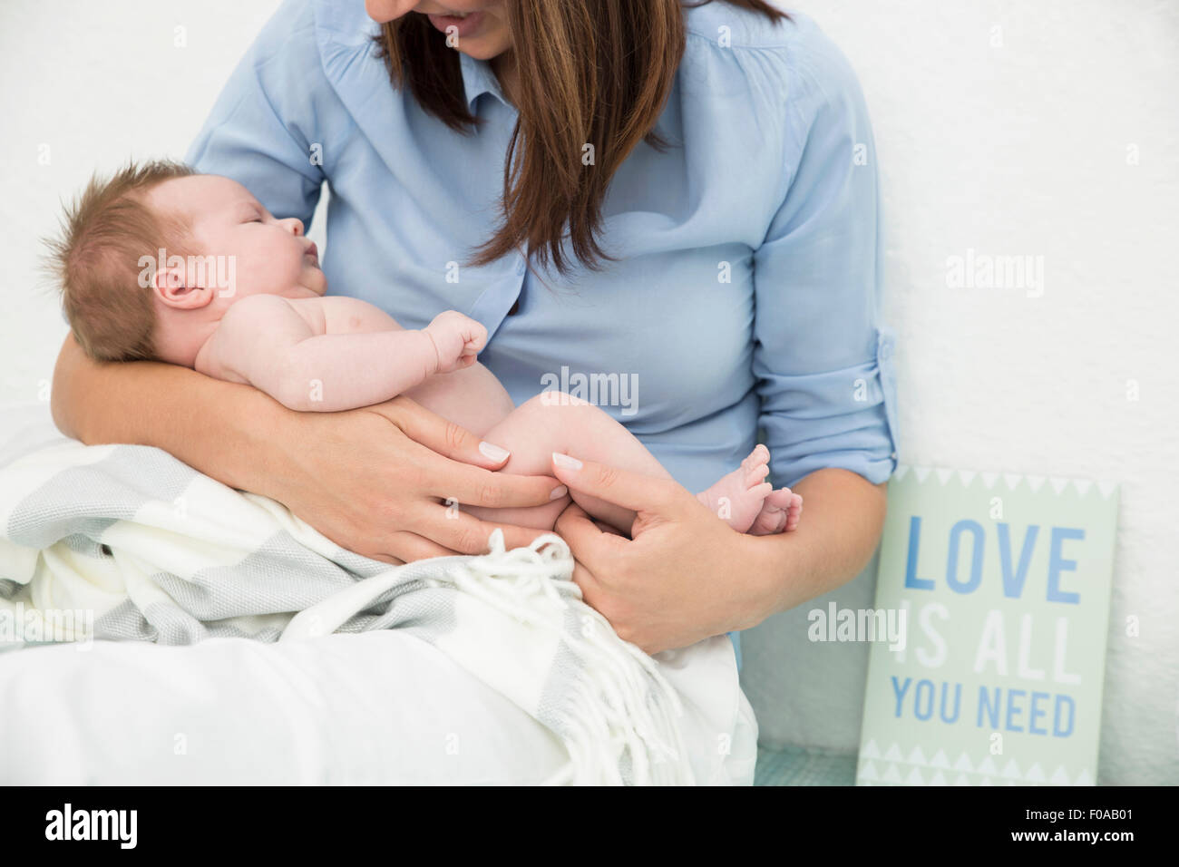 Mutter wiegt Baby in armen Stockfoto