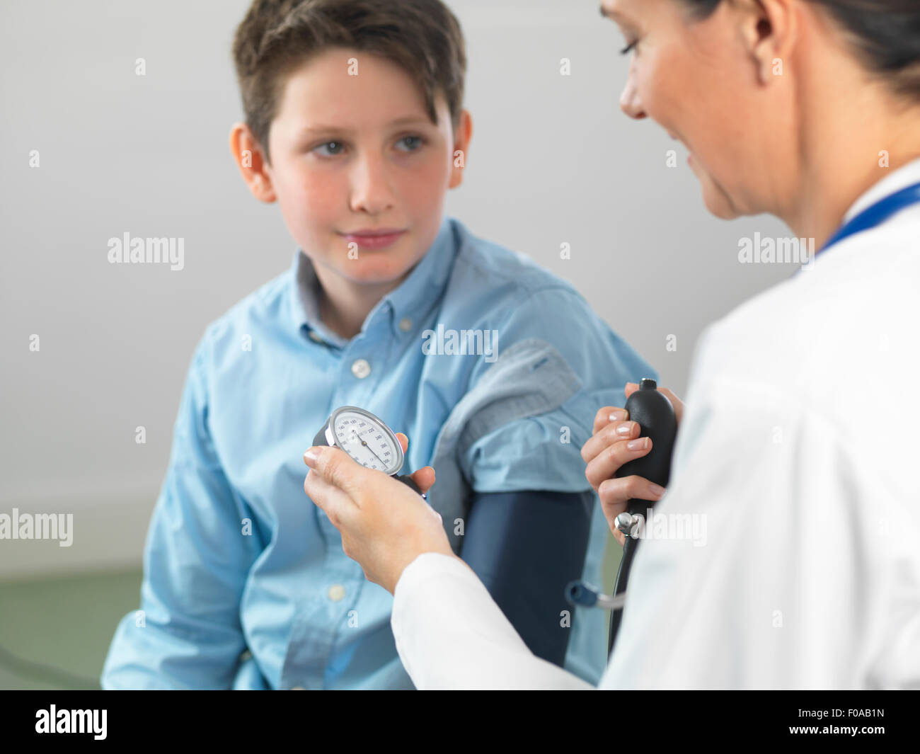 Arzt lesen Blutdruck jungen in Klinik Stockfoto