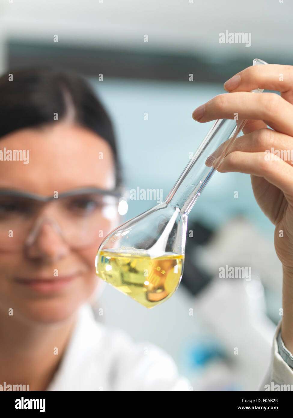 Chemiker, die Lösung in Kolben während Forschung Experiment betrachten Stockfoto