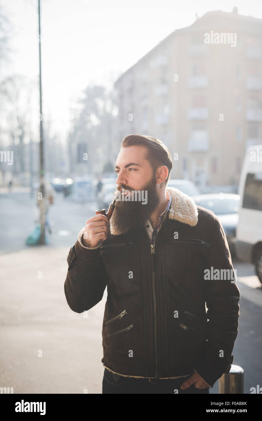 Junge bärtige Mann Pfeife auf Straße Stockfoto