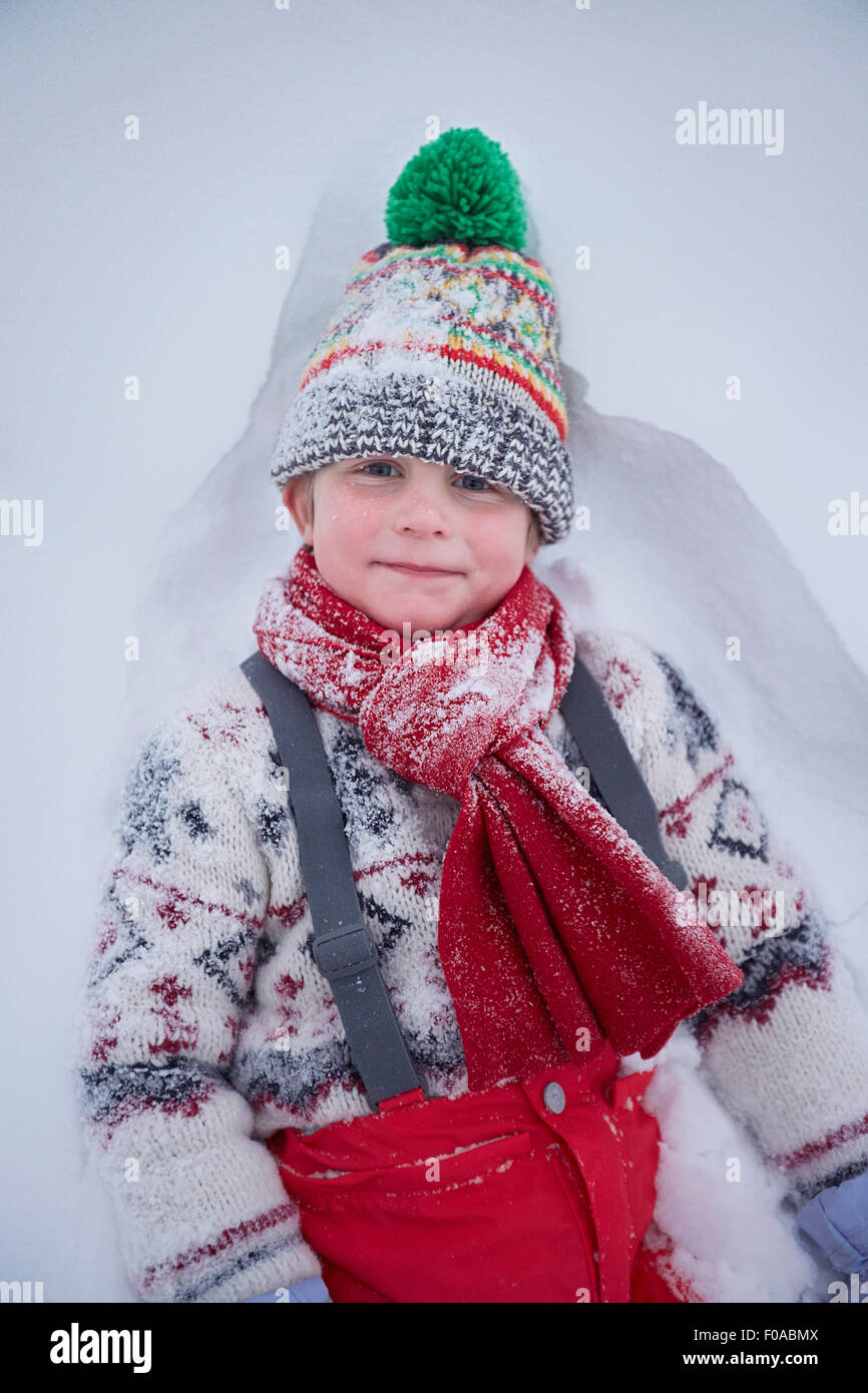 Porträt des netten jungen liegen im tiefen Schnee Stockfoto