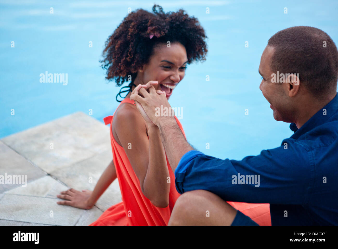 Stilvolle paar Lachen und Hand in Hand am Hotel Pool, Rio De Janeiro, Brasilien Stockfoto