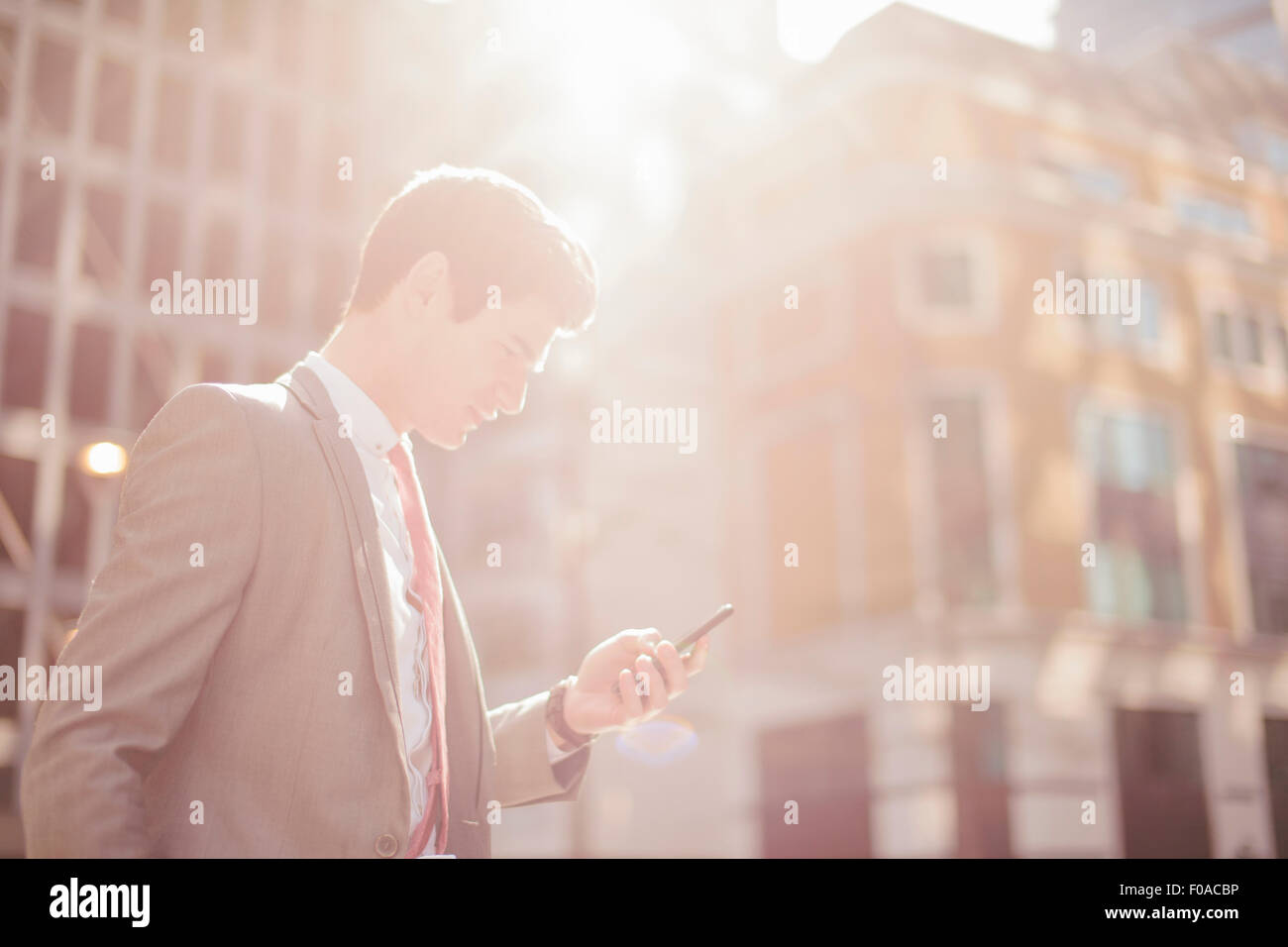 Junge Stadt Geschäftsmann Smartphone Texte zu lesen, während zu Fuß Stockfoto