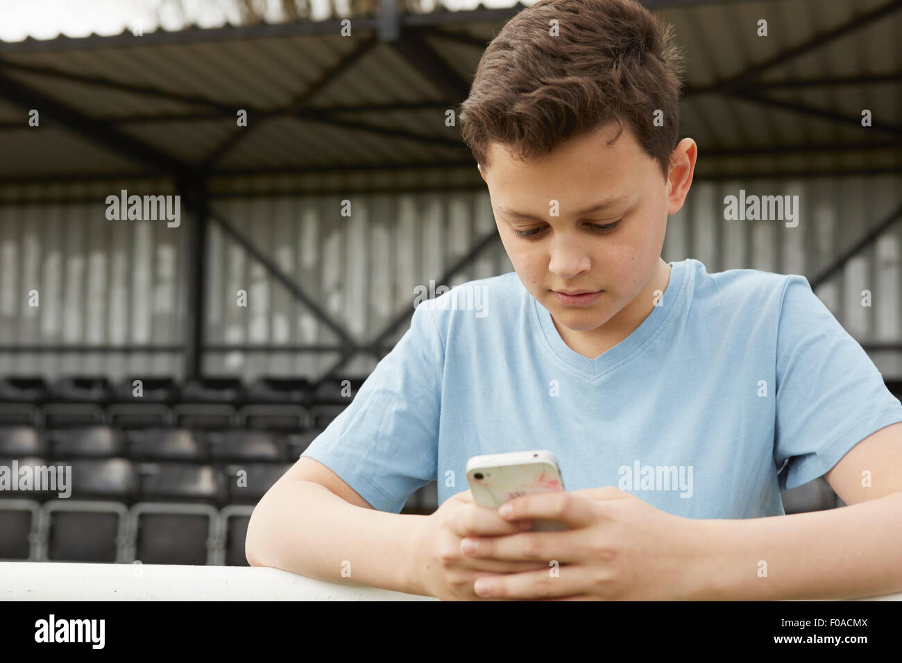 Jungen-SMS auf smartphone Stockfoto