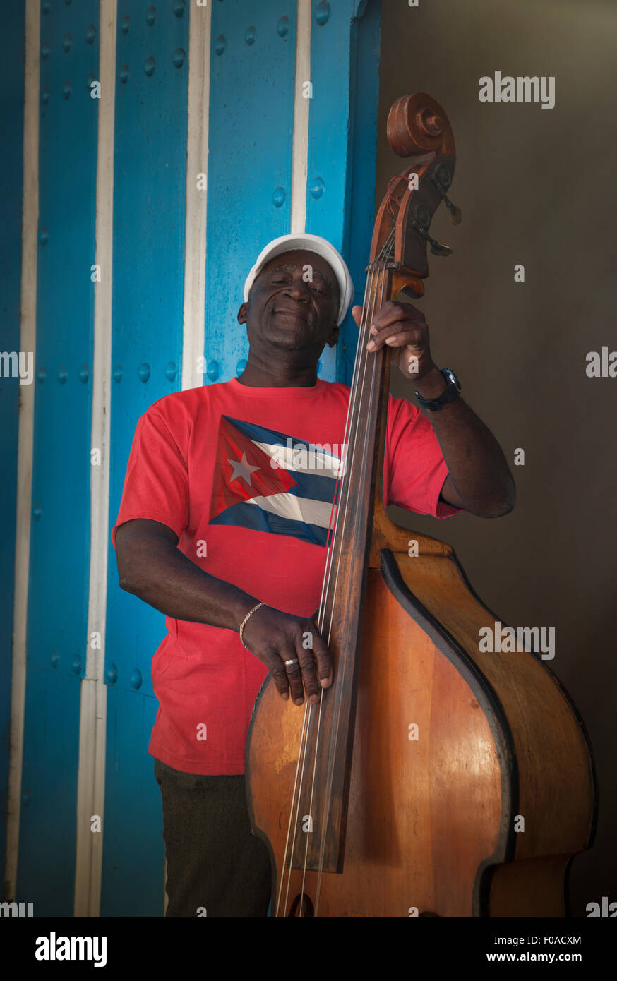 Ältere Mann spielt Kontrabass vor blauer Wand, Santiago De Cuba, Kuba Stockfoto