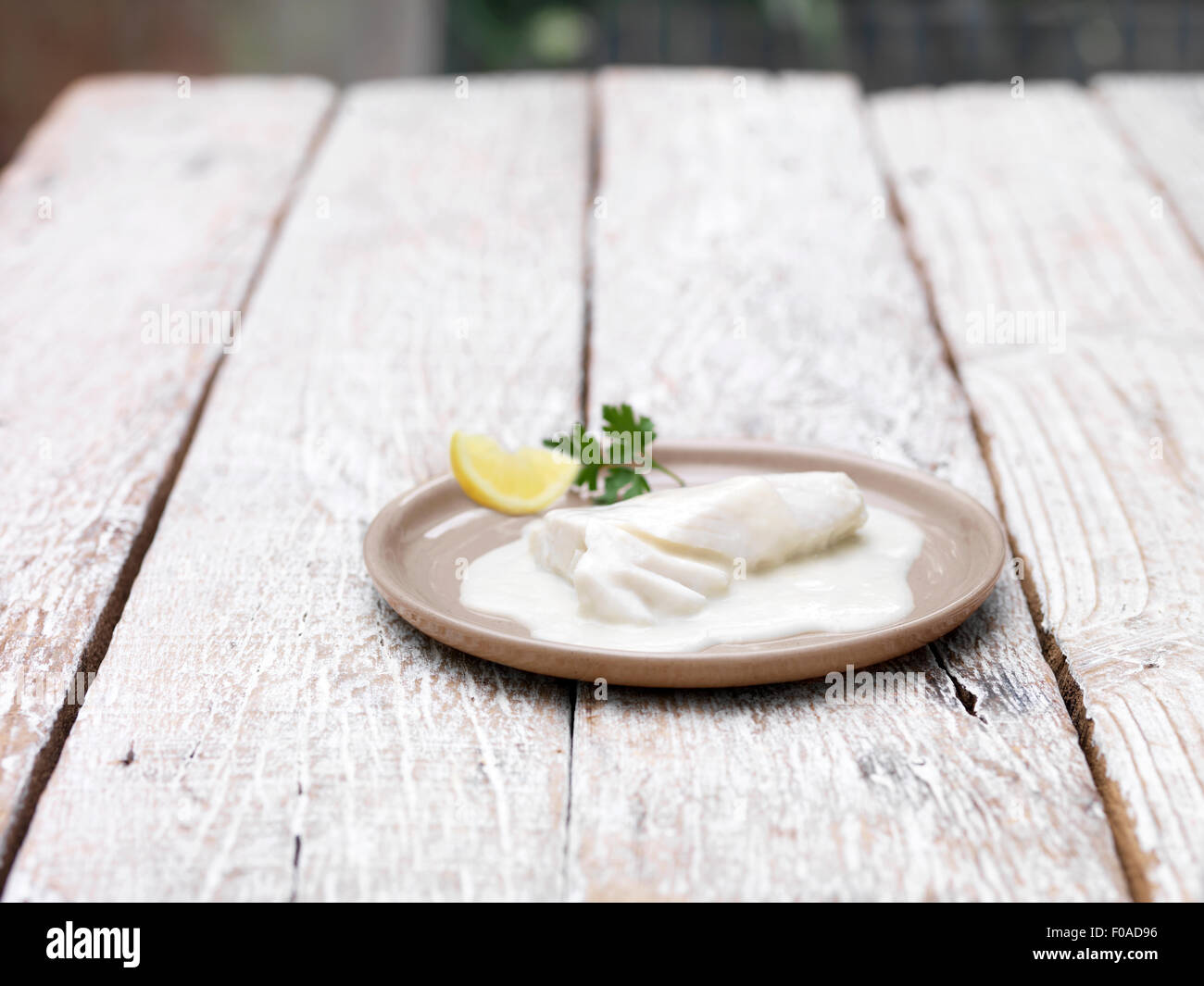Teller mit Backen im Beutel Schellfisch mornay auf Holztisch Stockfoto