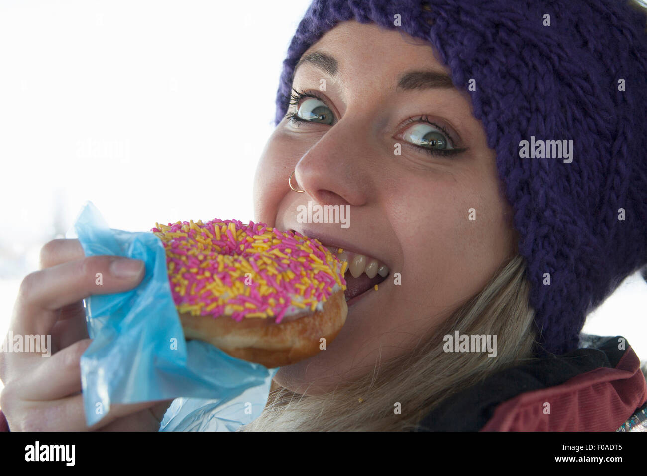 Junge Frau beißende Donut Stockfoto