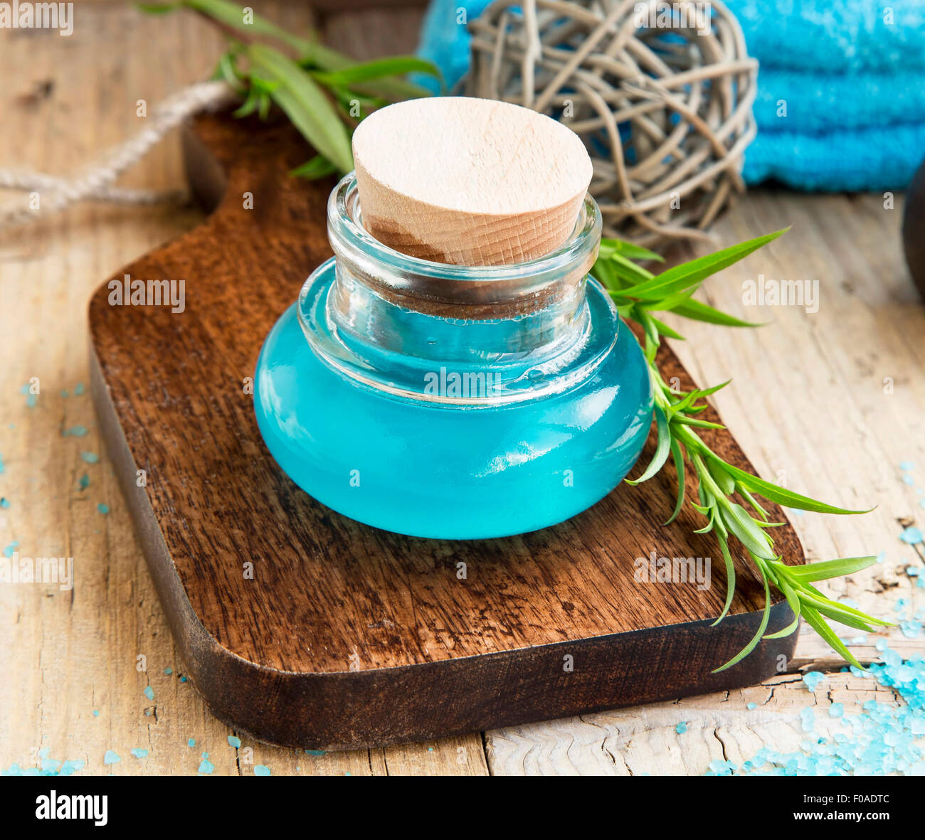 Wellness Stillleben Einstellung mit blauen Badeöl in einer Flasche mit Grünpflanze Stockfoto