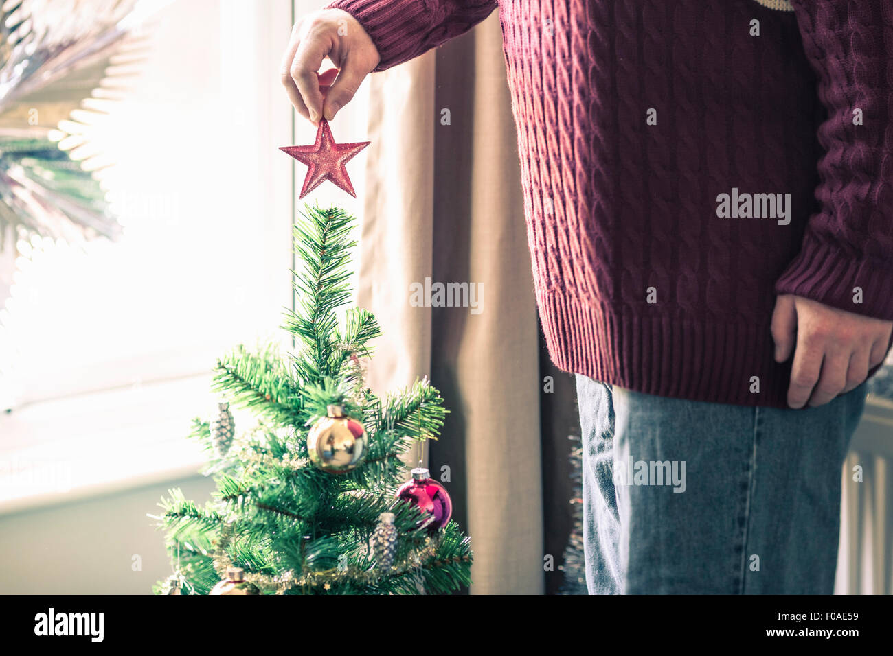 Person aufsetzen Weihnachtsbaum Sterne Stockfoto