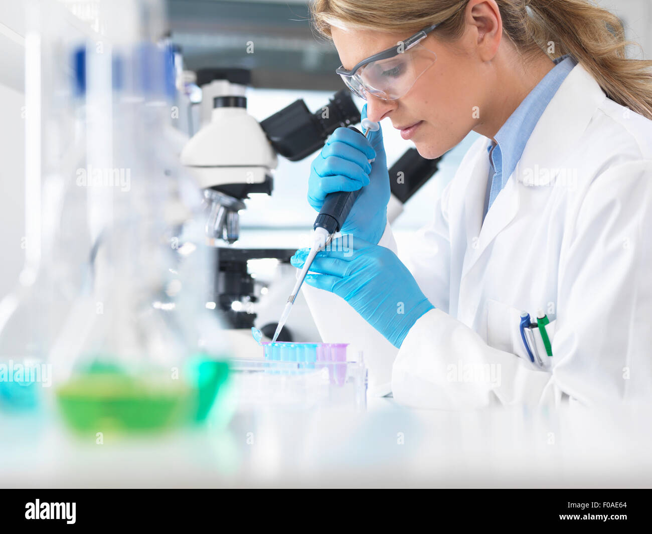 Wissenschaftlerin Pipettieren Probe in ein Fläschchen für analytische Untersuchungen im Labor Stockfoto