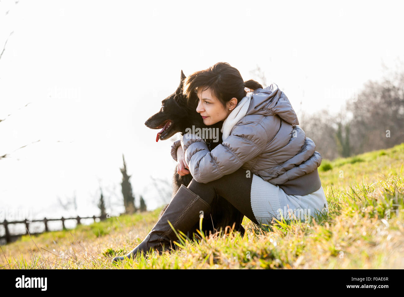 Mitte Erwachsene Frau und ihr Hund sitzt am Hang Stockfoto