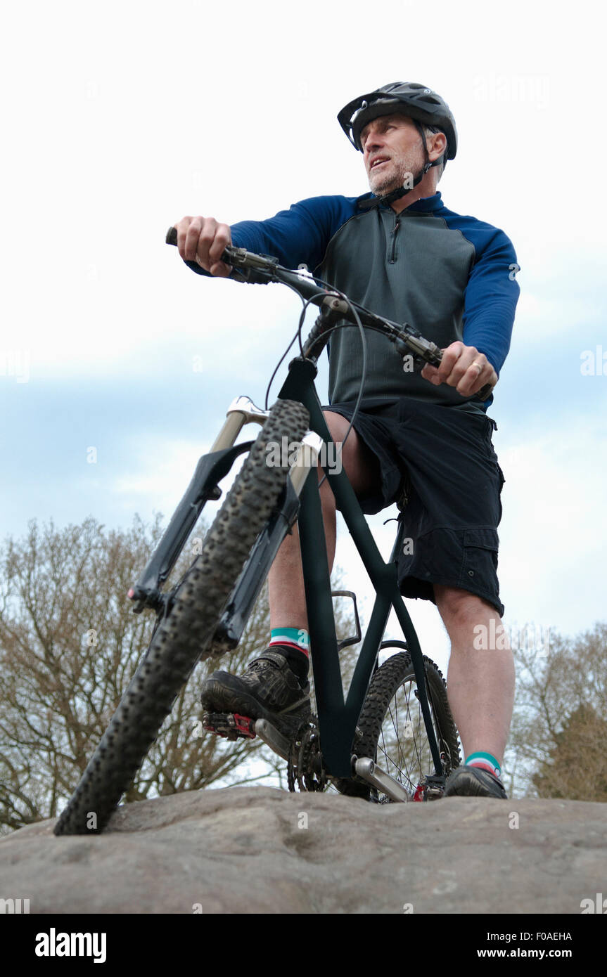 Niedrigen Winkel Blick auf ältere männliche Mountainbiker mit Blick vom Felsformation Stockfoto