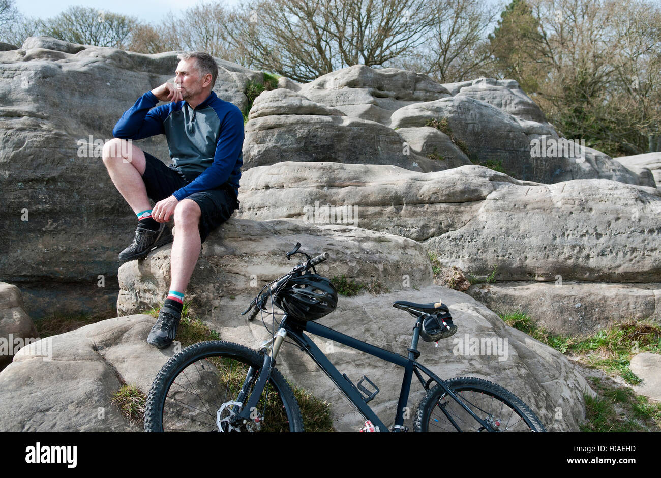 Ältere männliche Berg auf Felsformation sitzend Stockfoto