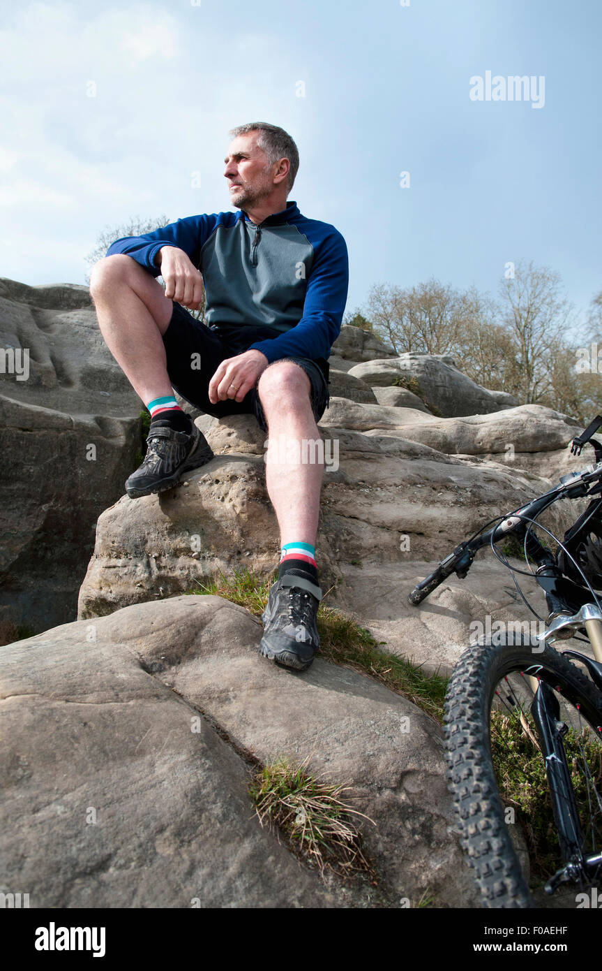 Ältere männliche Berg sitzen und mit Blick vom Felsformation Stockfoto