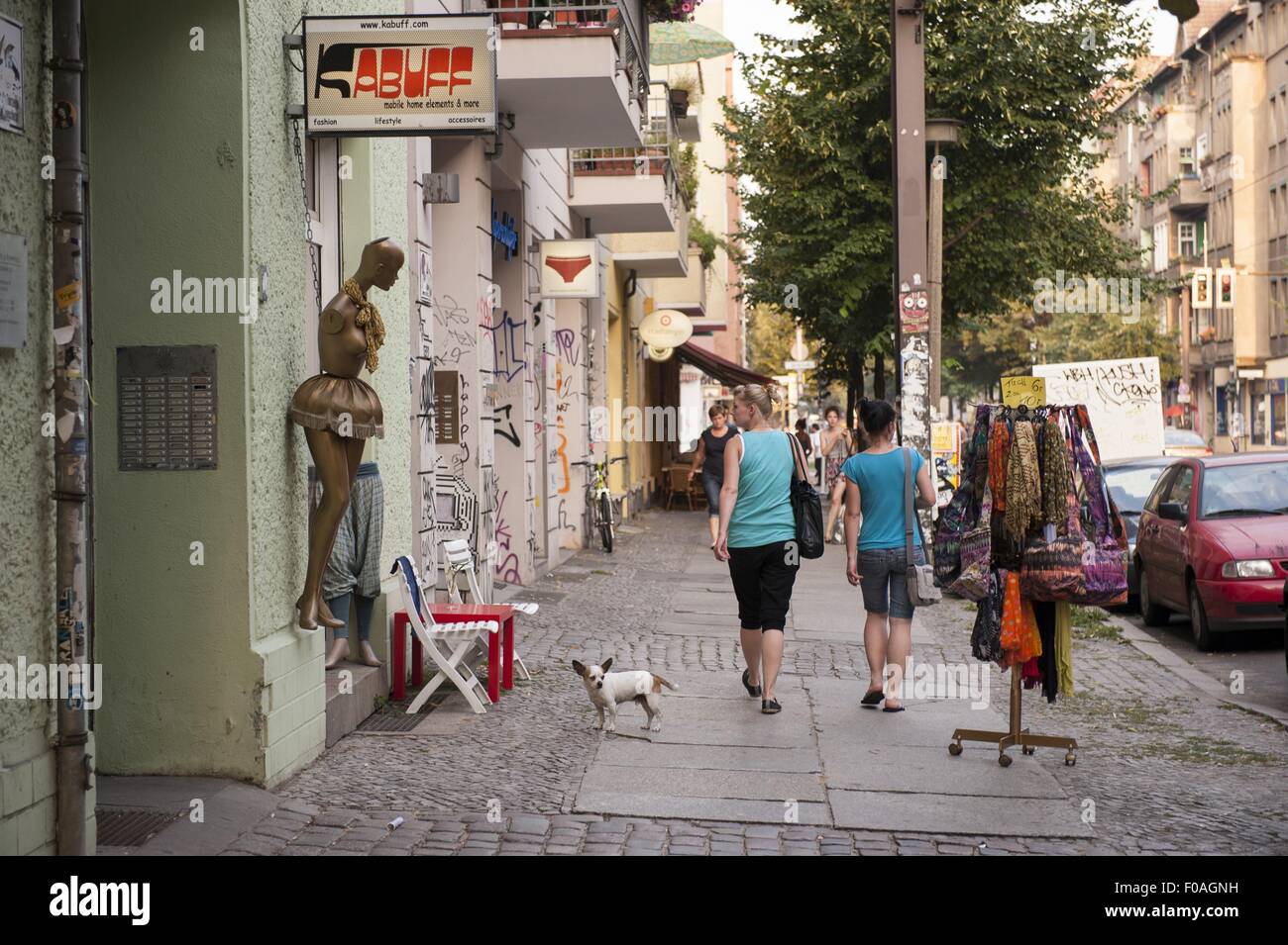 Leute sitzen im Café und einige gehen auf der Straße in Friedrichshain, Berlin, Deutschland Stockfoto