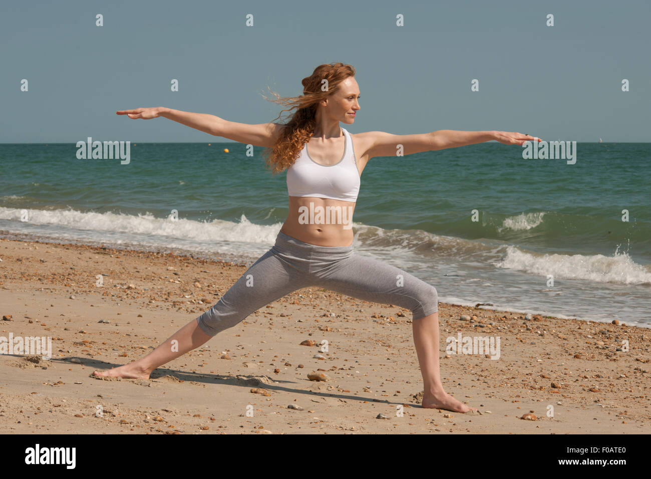 Frau macht Yoga und Pilates, stretching am Strand Stockfoto