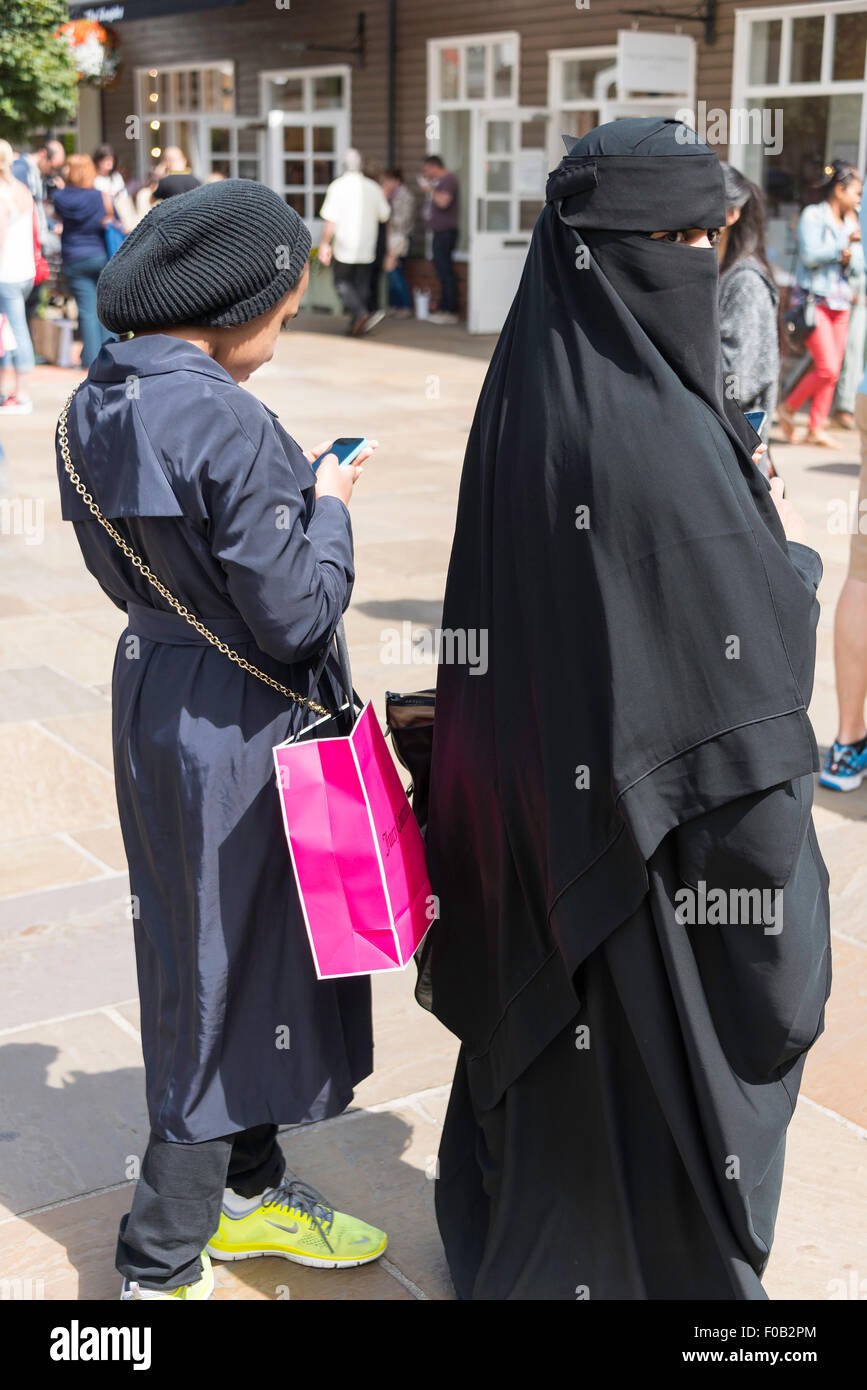 Muslimische Frau tragen von Burka und Mädchen in Bicester Village Outlet Shopping Centre, Bicester, Oxfordshire, England, Vereinigtes Königreich Stockfoto