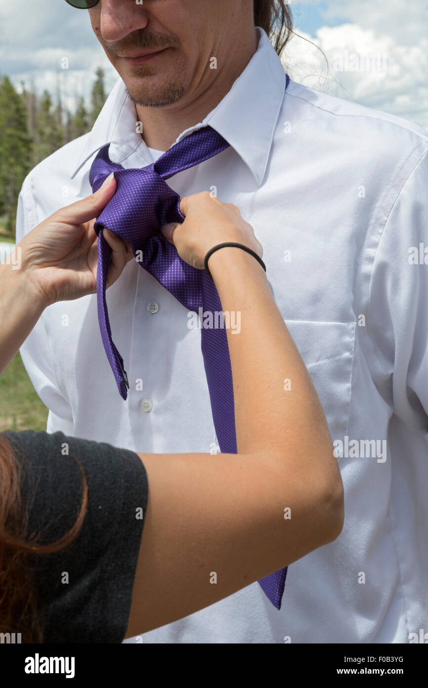 Dillon, Colorado - ein Brautführer bekommt Hilfe von einer Frau in seine Krawatte vor einer Hochzeit zu binden. Stockfoto